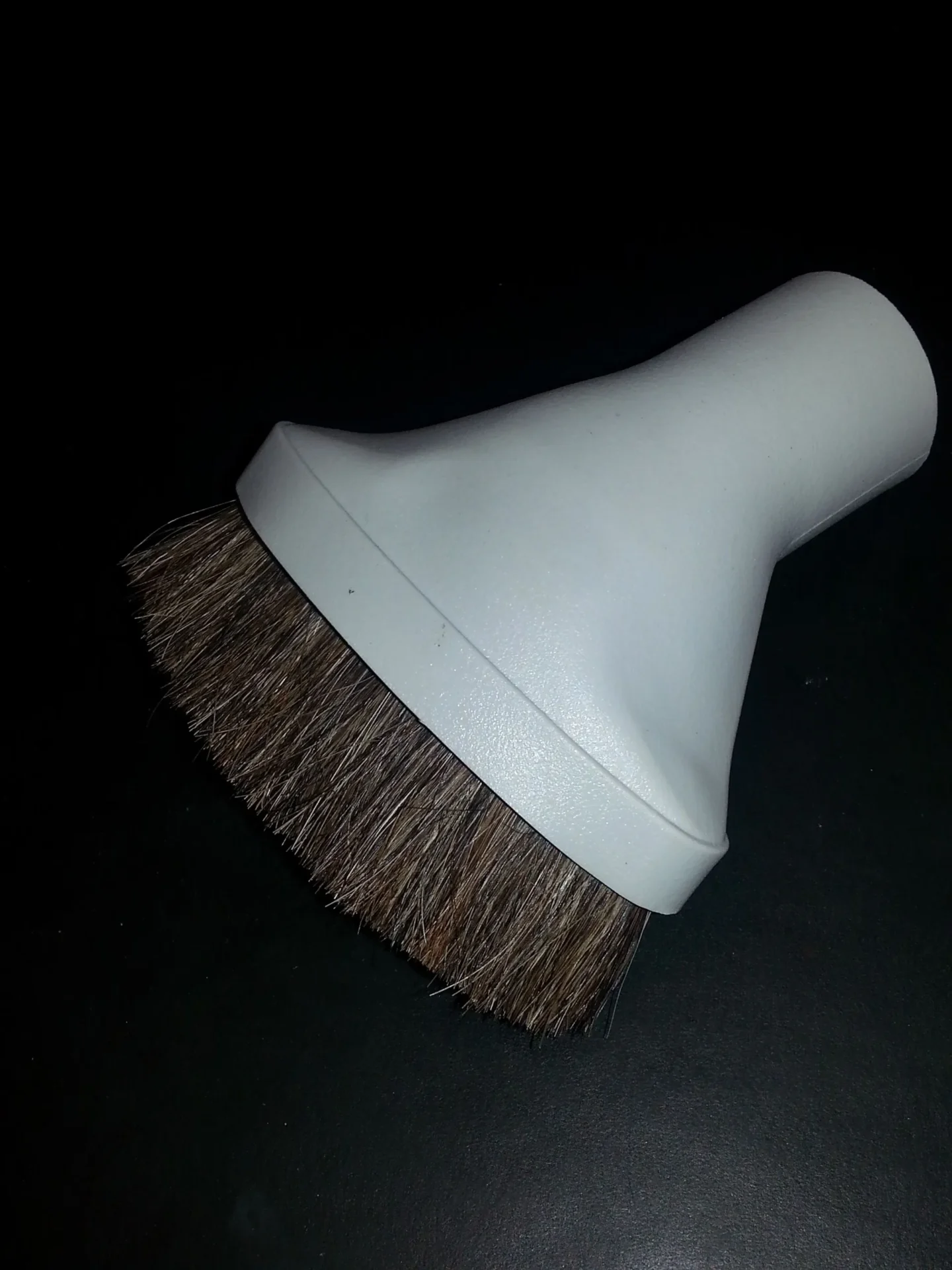 A white vacuum cleaner head with brown brush.