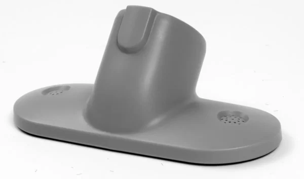 A gray plastic object is sitting on top of the floor.