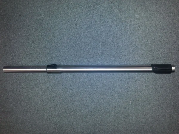 A silver pole with black handle on the ground.