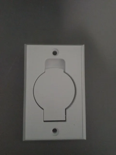 A white wall plate with a light on it.