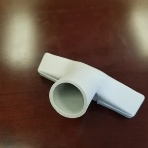 A white plastic pipe sitting on top of a wooden table.