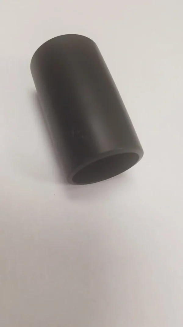 A tube of black plastic on top of a white surface.