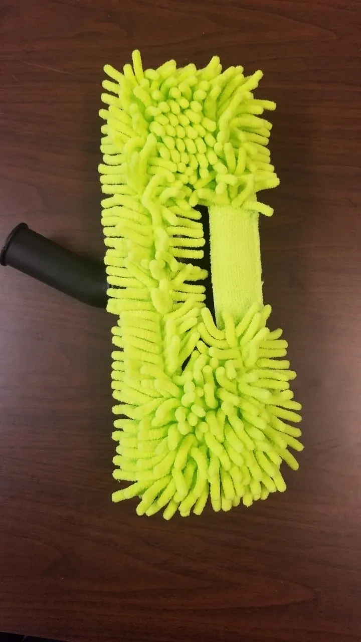 A yellow mop on top of a wooden table.
