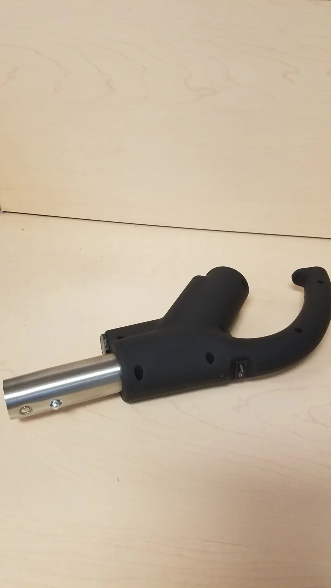A black handle with a metal tube attached to it.