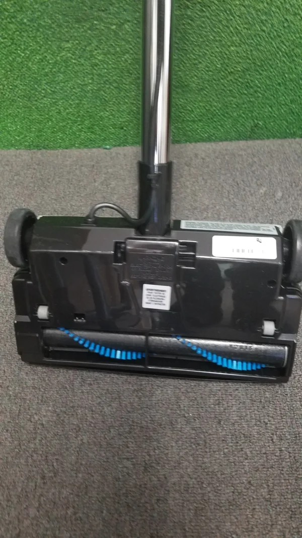A black and blue vacuum cleaner on the floor.