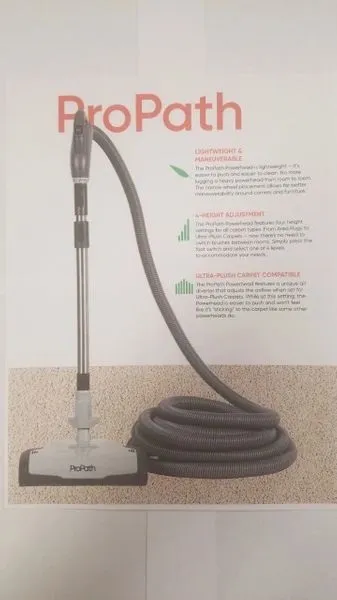 A vacuum cleaner is shown with its hose attached.