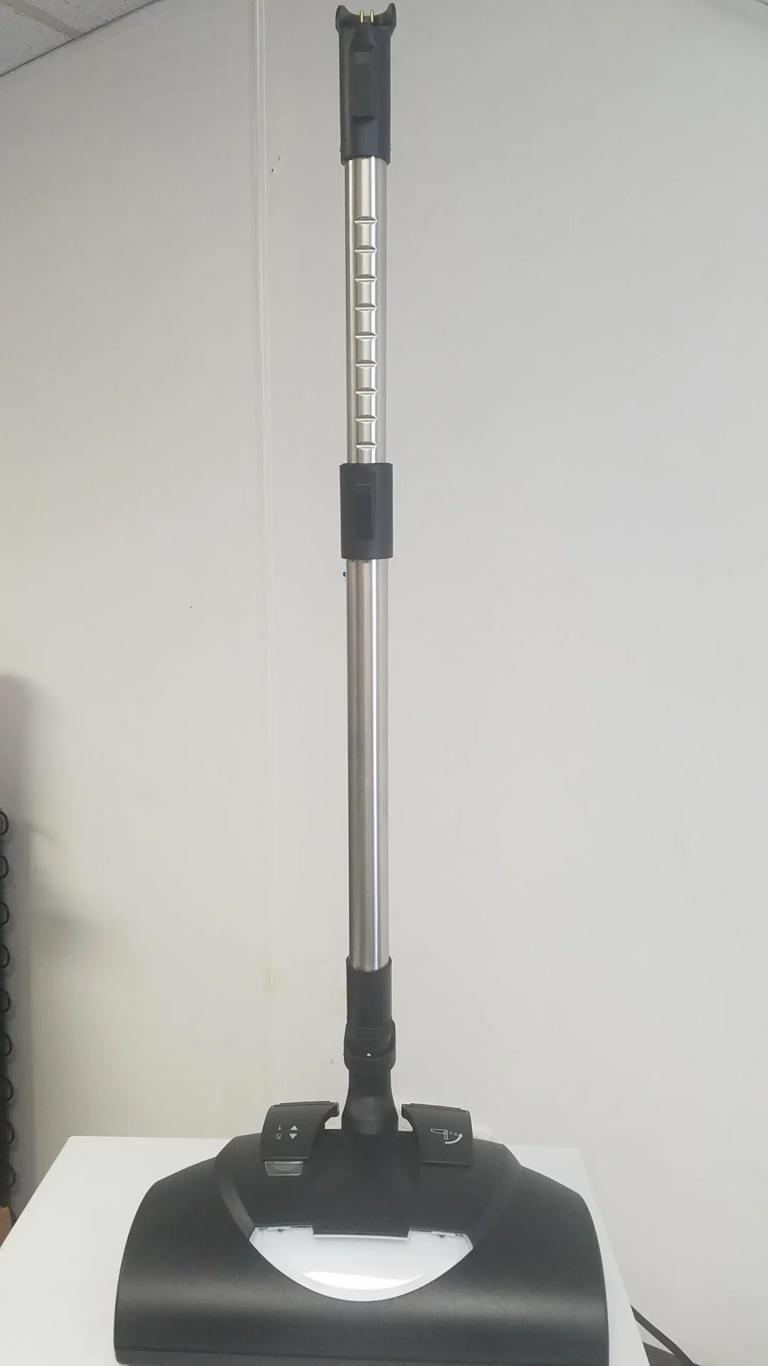 A pole with a black handle and a white background