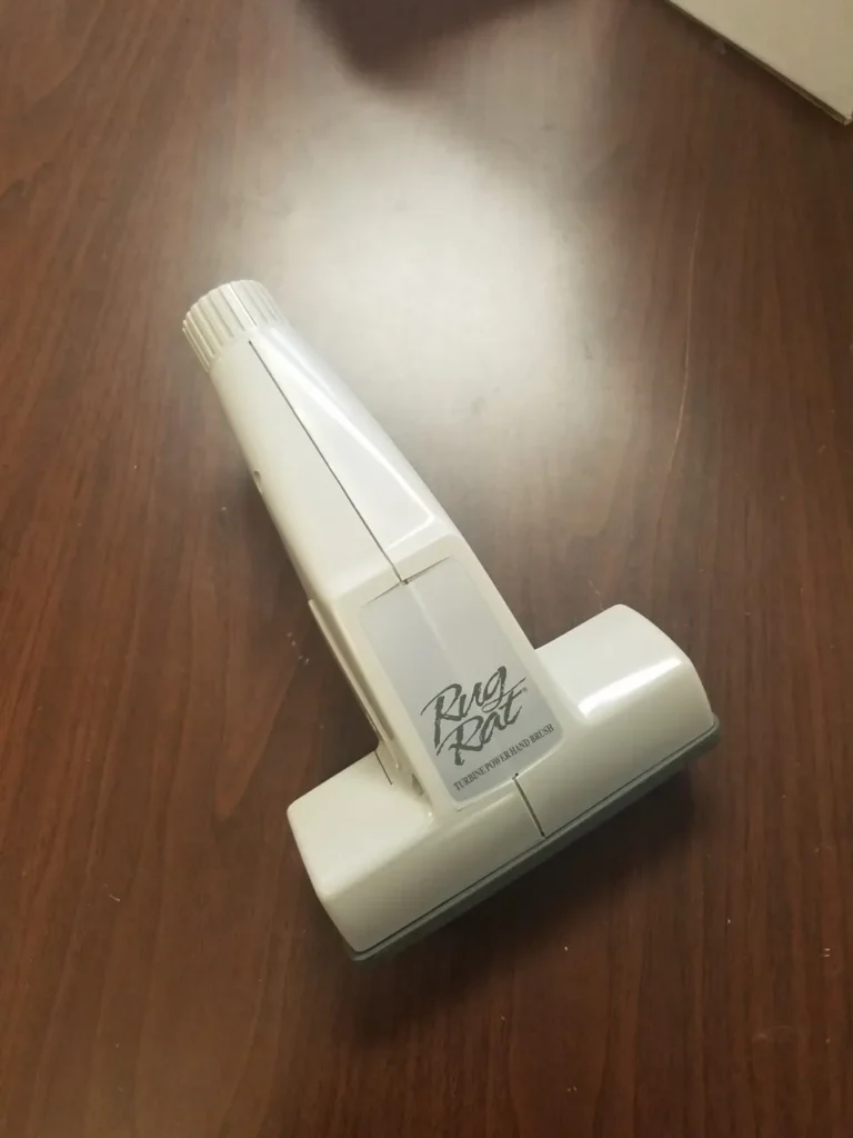 A white plastic object sitting on top of a wooden table.