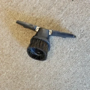 Round vacuum brush attachment on beige carpet