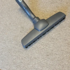 vacuum cleaner floor brush on beige carpet