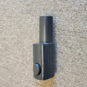 Gray vacuum wand adapter on beige carpet