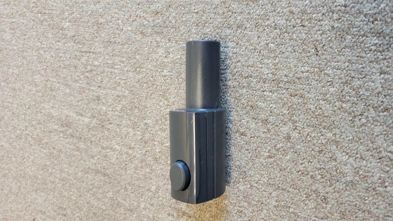 A black handle on the floor of a room.
