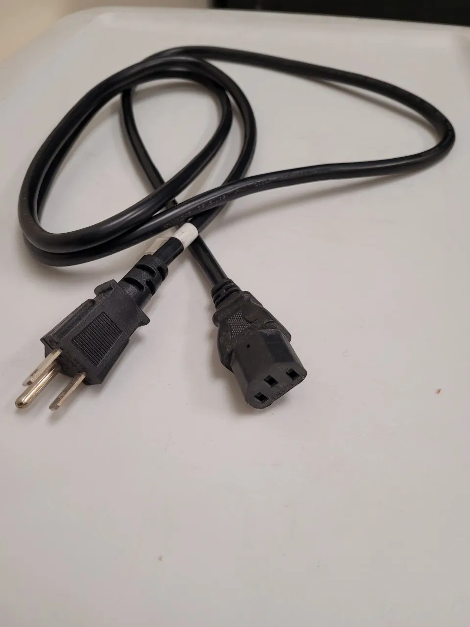 A black cord with two plugs on top of it.
