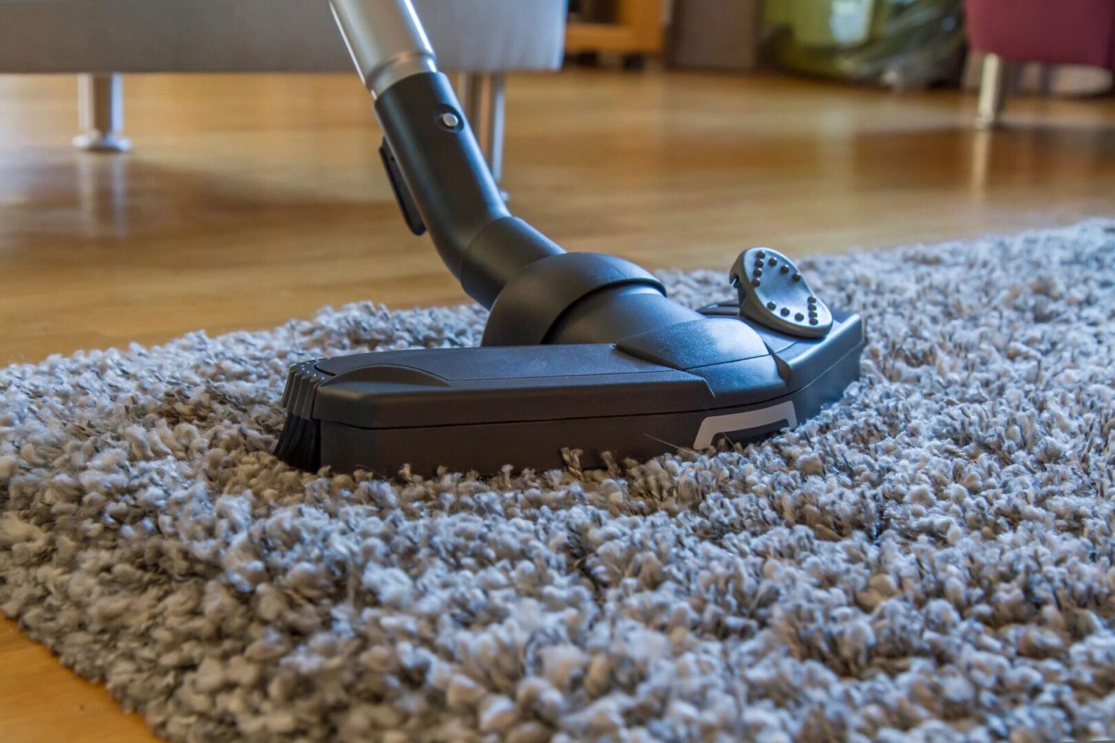 A vacuum cleaner is on the floor of a carpet.