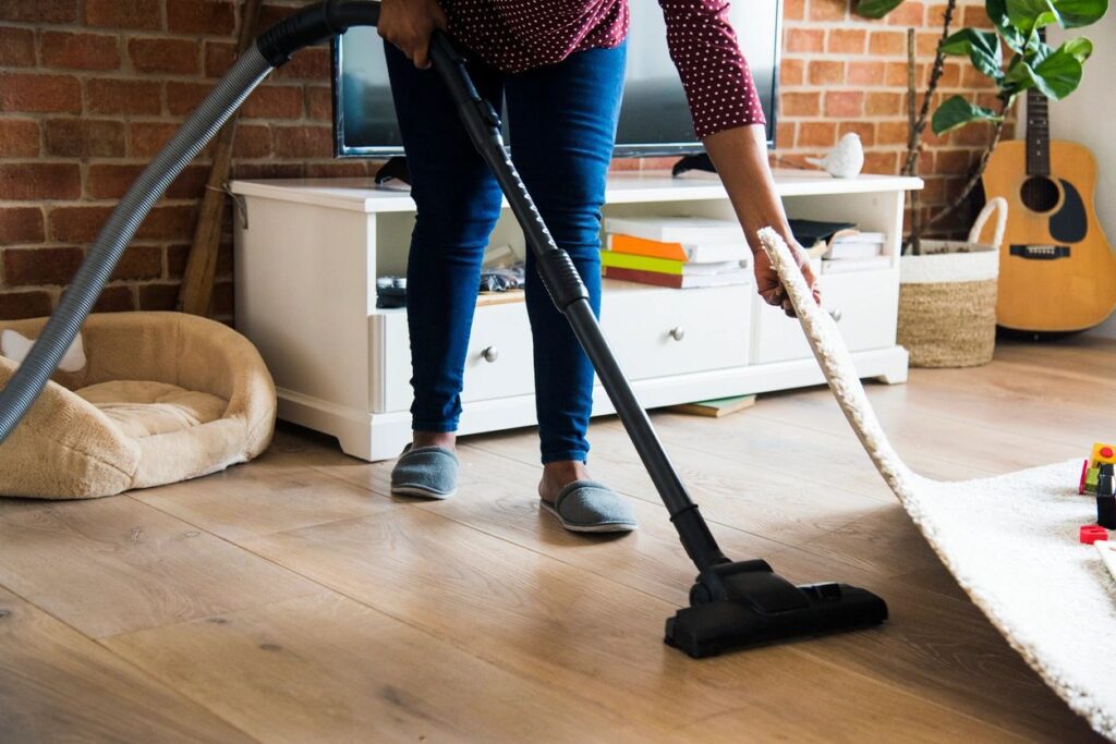 A person using a vacuum on the floor