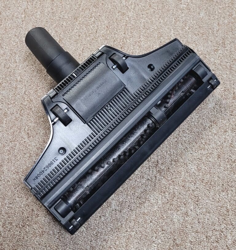 Vacuum cleaner attachment on carpet surface.