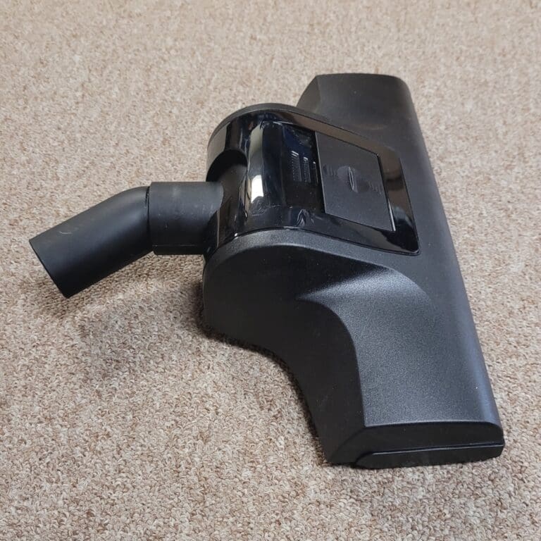 Vacuum cleaner attachment on carpeted surface.