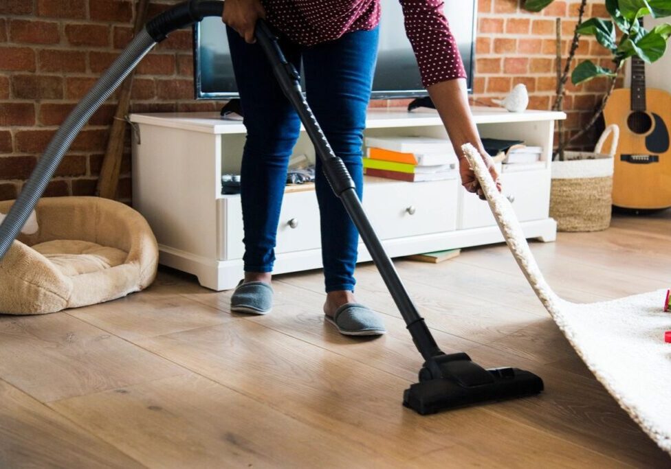 A person using a vacuum on the floor